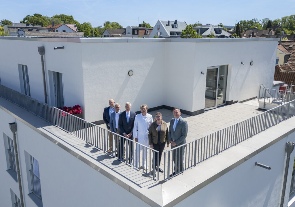 Gruppenfoto vor dem obersten Stockwerk der Klinik.