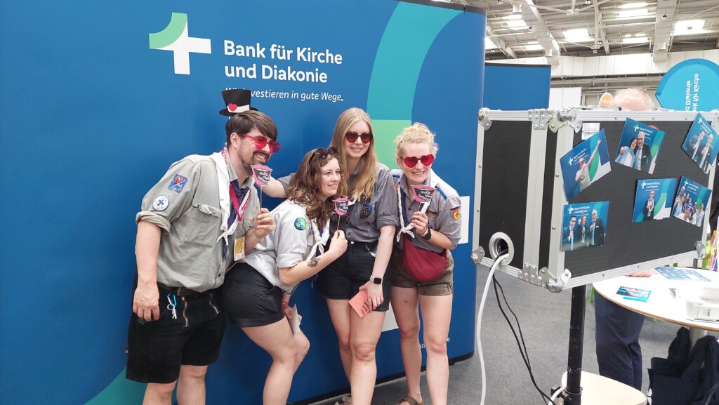 Menschen stehen vor Leinwand mit KD-Bank Logo.