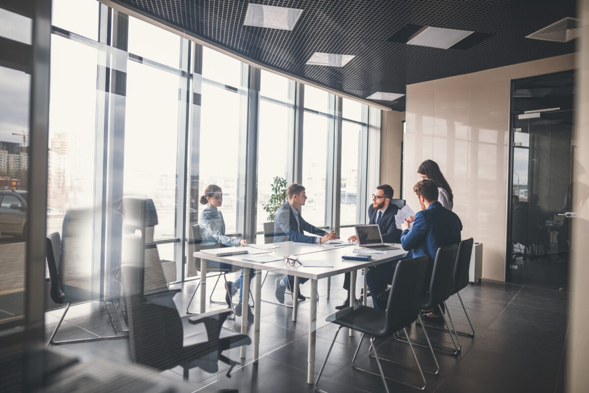 Business Menschen im Büro sitzen um Konferenztisch