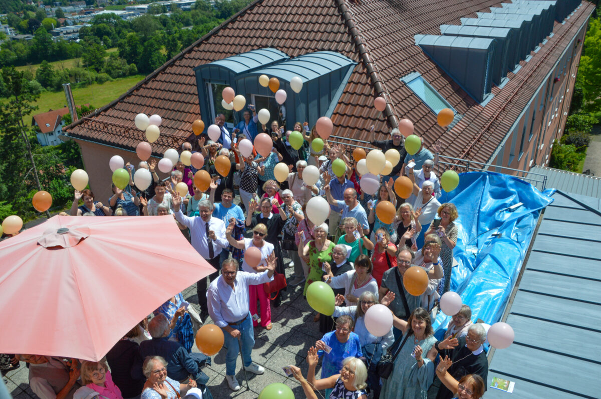 Menschen mit Luftballons auf Dachterasse